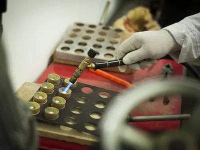 A gold sample being prepared with a torch before cupellation