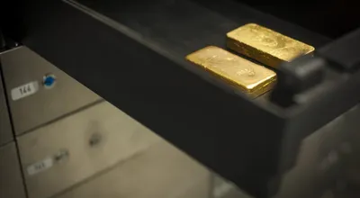 Gold bars resting in an open vault safe-deposit drawer