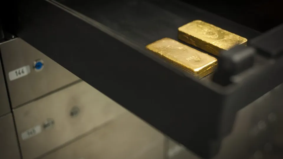 Gold bars resting in an open vault safe-deposit drawer