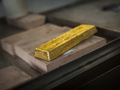 A cast gold bar resting on firebrick