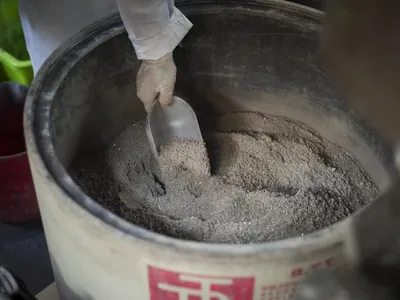 A technician scooping precipitate for processing